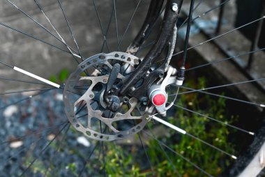 park halindeki bir bisikletin bozuk disk frenine yakın çekim.