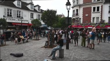 Paris, Fransa 30 Ağustos 2024 Montmartre sokaklarında turist, sokak sanatçısı ve satıcılarından oluşan bir kalabalık