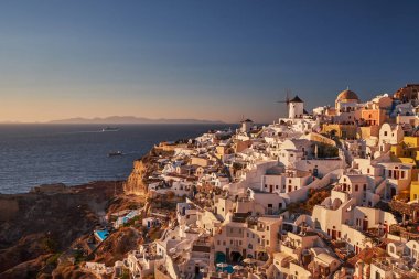 Yunanistan 'ın batımında, Ege Denizi' nin Santorini adasındaki geleneksel beyaz evleri ve yel değirmenleriyle eski Oia Şatosu 'nun güzel manzarası