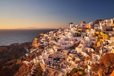 Yunanistan 'ın batımında, Ege Denizi' nin Santorini adasındaki geleneksel beyaz evleri ve yel değirmenleriyle eski Oia Şatosu 'nun güzel manzarası