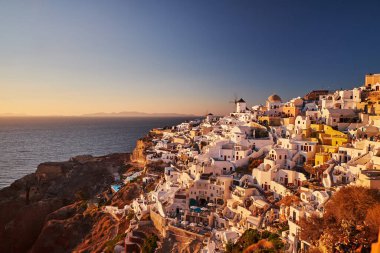 Yunanistan 'ın batımında, Ege Denizi' nin Santorini adasındaki geleneksel beyaz evleri ve yel değirmenleriyle eski Oia Şatosu 'nun güzel manzarası