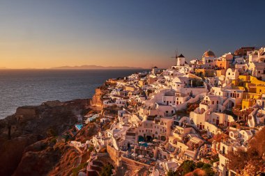 Yunanistan 'ın batımında, Ege Denizi' nin Santorini adasındaki geleneksel beyaz evleri ve yel değirmenleriyle eski Oia Şatosu 'nun güzel manzarası