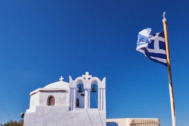 Yunan Bayrağı taşıyan Küçük bir Kilisenin Beyaz Çan Kulesi - Pyrgos Köyü, Santorini Adası, Yunanistan
