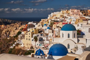 Yunanistan 'ın Santorini Adası' ndaki Oia Köyü ve Mavi Kubbe Kilisesi 'nin Panoramik Hava Görüntüsü - Caldera Kayalıklarındaki Geleneksel Beyaz Evler - Günbatımı