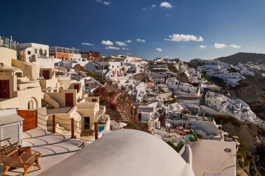 Yunanistan 'ın Santorini Adası' ndaki Oia Köyü ve Mavi Kubbe Kilisesi 'nin Panoramik Hava Görüntüsü - Caldera Kayalıklarındaki Geleneksel Beyaz Evler - Günbatımı