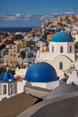 Yunanistan 'ın Santorini Adası' ndaki Oia Köyü ve Mavi Kubbe Kilisesi 'nin Panoramik Hava Görüntüsü - Caldera Kayalıklarındaki Geleneksel Beyaz Evler - Günbatımı