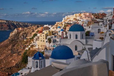 Yunanistan 'ın Santorini Adası' ndaki Oia Köyü ve Mavi Kubbe Kilisesi 'nin Panoramik Hava Görüntüsü - Caldera Kayalıklarındaki Geleneksel Beyaz Evler - Günbatımı