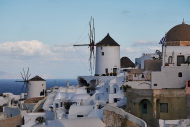 Yunanistan 'ın batımında Ege Denizi' ndeki Santorini adasında geleneksel beyaz evleri ve yel değirmenleriyle eski Oia köyünden güzel bir manzara