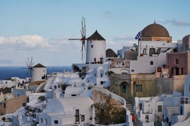 Yunanistan 'ın batımında Ege Denizi' ndeki Santorini adasında geleneksel beyaz evleri ve yel değirmenleriyle eski Oia köyünden güzel bir manzara