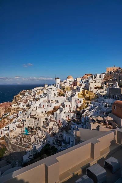 Yunanistan 'ın batımında Ege Denizi' ndeki Santorini adasında geleneksel beyaz evleri ve yel değirmenleriyle eski Oia köyünden güzel bir manzara
