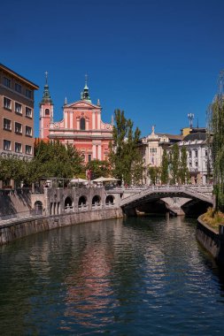 Ljubljanica Nehri üzerindeki üçlü köprü ve Ljubljana, Slovenya 'daki Fransisken Annunciation Kilisesi