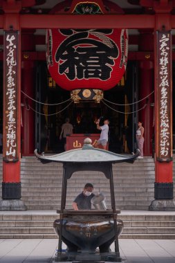 Asakusa, Tokyo, Japonya 'daki Senjo-ji Kannon Tapınağındaki Tütsüden Külleri Toplayan Adam