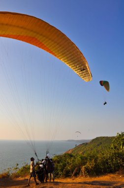 Arambol sahili, Goa, Hindistan 'da bir paraglider çıkartmaya hazırlanıyor.