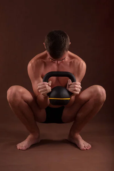 Handsome Muscular Adolescent Shirtless Boy Training Deep Squat Exercise Kettlebell Stockbild