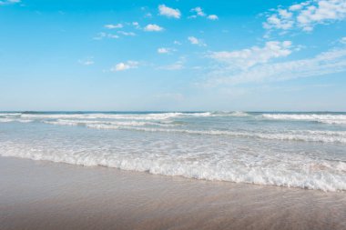 Güneşli bir günde plaj manzarası. Güneş, kum ve denizin çarpıcı bir portresi..