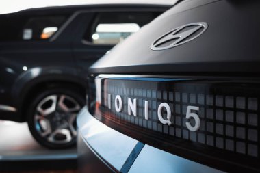 Hyundai Ioniq 5 'in arkası, modern amblem ve LED detaylarını vurguluyor, arka planda olay yerini düzenleyen başka bir SUV daha var..