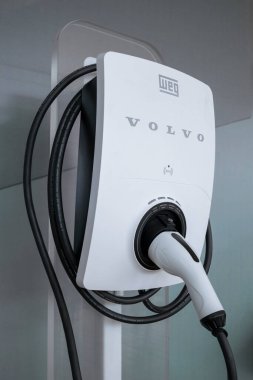 Volvo marka elektrikli araç şarj aleti, Weg tarafından üretilmiş, bağlı bir bağlantı cihazı ve ekipmanın etrafına sarılı olan kablo..