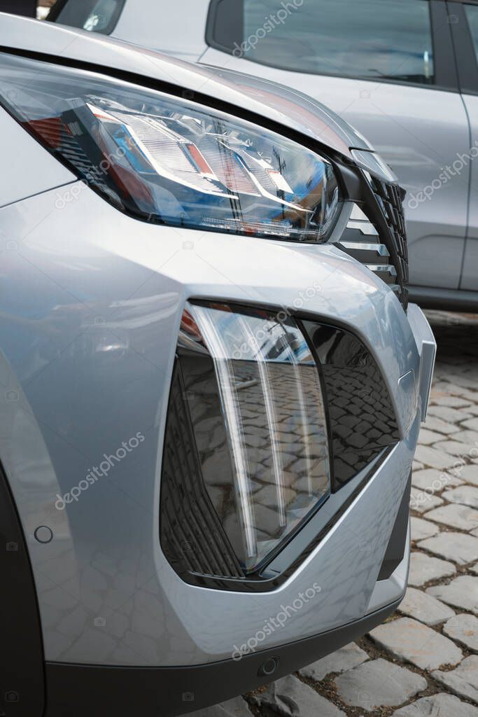Close-up of the front of a modern car, highlighting the stylish headlight and aggressive design elements of the front bumper