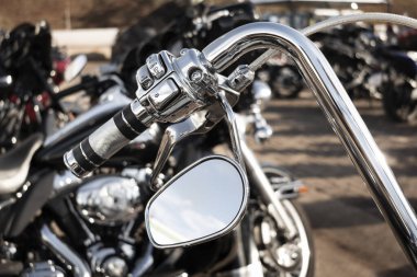 Bir motorun krom gidonun ayrıntıları. Kolu, elektrik kontrolleri ve yan aynası var..