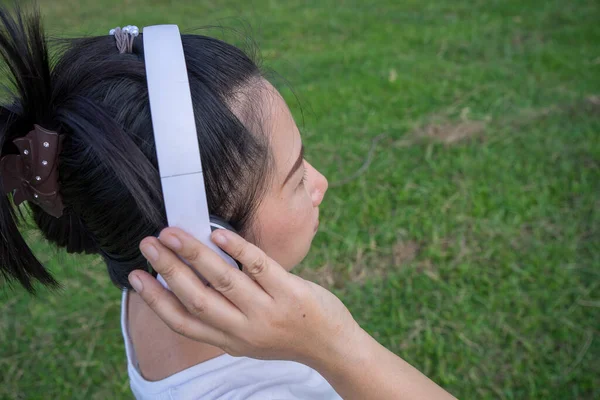 Słodkie Azji Kobieta Słuchać Muzyka Trzymając Biały Słuchawki Tyłu Strzał — Zdjęcie stockowe