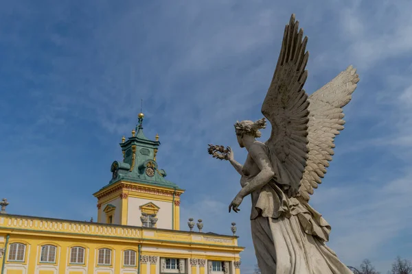 天使的塑像手里拿着一个花圈 朝向华沙的维拉诺夫斯基宫 那塑像是在蓝天的背景下 从下面看去 — 图库照片