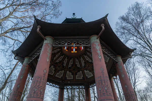 stock image gazebo with concrete columns in Chinese style with stained glass windows in the park in early spring