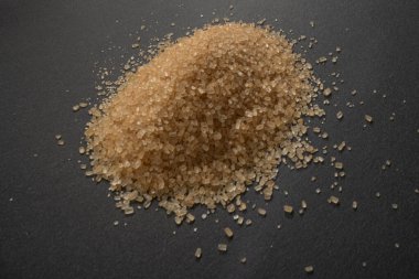 Siyah zemin üzerinde kahverengi şeker makrosu granülleri