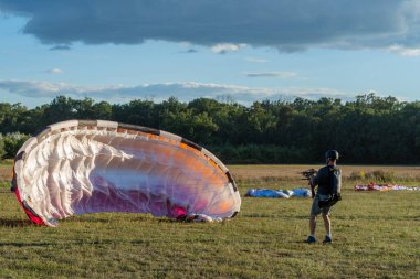 Learn to paraglider, paraglider catching wind flow from the ground in summer warm weather with blue sky and white clouds background