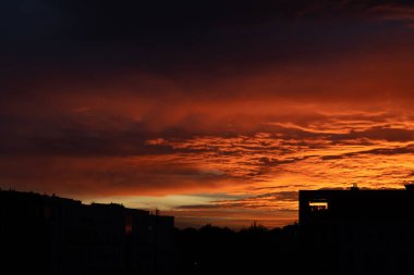 beautiful red orange sunset with silhouette of houses