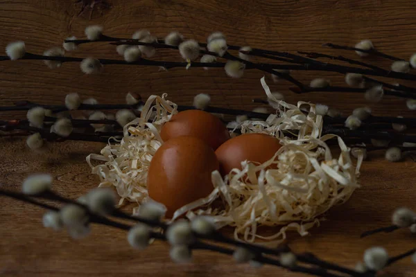 彩蛋巢中的彩蛋 有柳枝 木制背景 — 图库照片