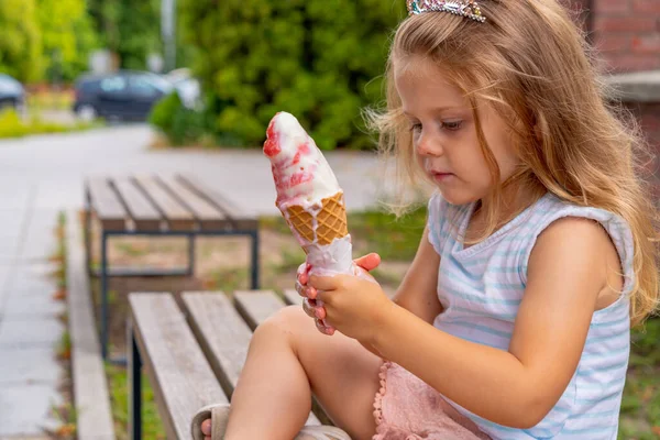 可爱的小女孩在夏天的花园里吃冰淇淋 有选择的重点 图库照片