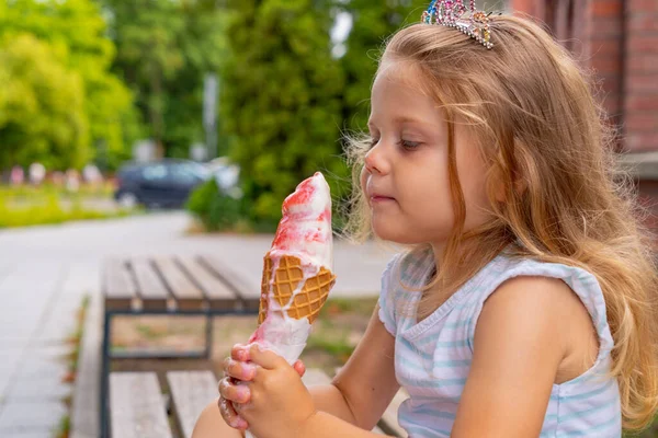 可爱的小女孩在夏天的花园里吃冰淇淋 有选择的重点 免版税图库图片