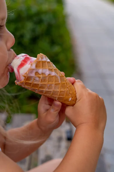 可爱的小女孩在夏天的花园里吃冰淇淋 有选择的重点 图库图片