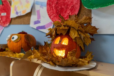 Rafta balkabakları ve sonbahar yapraklarıyla Cadılar Bayramı süslemesi.