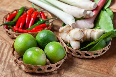 Tom Lezzetli Baharatlı Çorba Limonlu Biberli Limon Çimi, Ahşap kırsal arka planda galangal kaffir limon yaprakları 