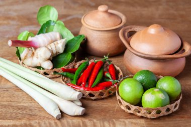 Tom Lezzetli Baharatlı Çorba Limonlu Biberli Limon Çimi, Ahşap kırsal arka planda galangal kaffir limon yaprakları 