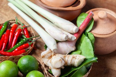 Tom Lezzetli Baharatlı Çorba Limonlu Biberli Limon Çimi, Ahşap kırsal arka planda galangal kaffir limon yaprakları 