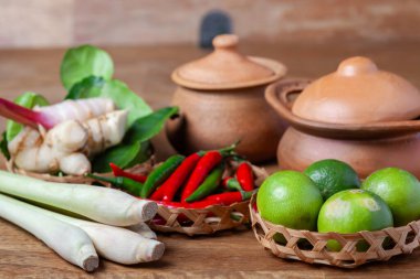 Tom Lezzetli Baharatlı Çorba Limonlu Biberli Limon Çimi, Ahşap kırsal arka planda galangal kaffir limon yaprakları 
