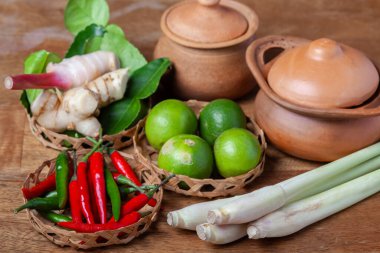 Tom Lezzetli Baharatlı Çorba Limonlu Biberli Limon Çimi, Ahşap kırsal arka planda galangal kaffir limon yaprakları 