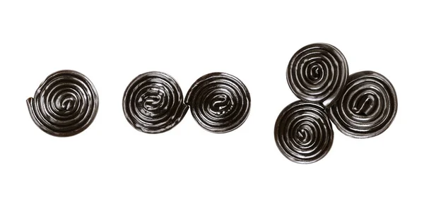 3つのケルトの螺旋状のモチーフを形成する酒の車輪 1つと2つのスパイラルとトリスケリオン リコリスの切断 甘草植物の根の抽出物と黒の色 食べ物の写真 — ストック写真