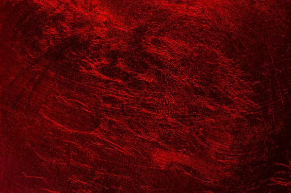 stock image Shimmering metallic plastic film, and dark red background, with random structured surface. Furrowed and with a texture that looks like hell, lava, or the surface of planet Mars. Close-up, from above.