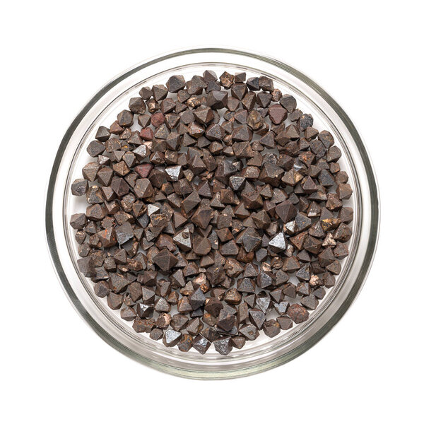 Кристаллы магнетита в стеклянной тарелке. Оксид железа (II, III), октаэдр, двойная пирамидальная форма (платоническое тело). Наиболее магнитные из всех природных минералов. Можно также найти в человеческом мозге.