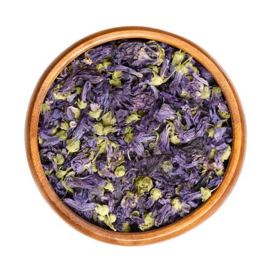 Ahşap bir kasede kurutulmuş mor mallow çayı çiçekleri. Malva Sylvestris 'in leylak-mor çiçekli başları, yaygın olarak bilinen şekerlemeler, bitki çayı ve geleneksel tıpta kullanılır. Yakından, yukarıdan..