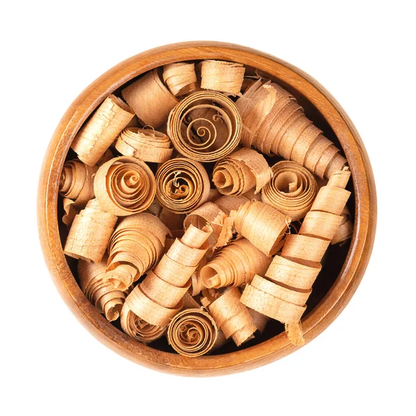 Spiral shaped wood shavings of Swiss pine wood, in a wooden bowl. Pinus cembra, European white pine tree, with distinctive smell, coming from essential oil pinosylvin, keeping away moths and insects.