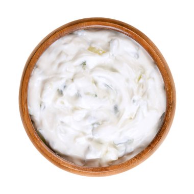 Tzatziki, ahşap bir kasede. Aperatif (meze) veya meze olarak sunulan taze Yunan sos, salatalık, sarımsak, tuz, zeytinyağı ve dereotu, nane veya maydanozla karıştırılmış süzme yoğurttan yapılıyor..