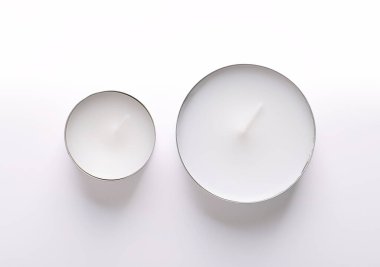 Tealight ve Maxi Tealight, yukarıdan. Aynı zamanda çay mumu veya t-lite olarak da adlandırılan iki çeşit çay lambası, farklı yakma zamanına sahip, ve ince metal bir bardak, yani mum tamamen yanarken sıvılaştırılabilir..