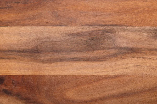 Surface of an olive wood board. Glued together dried boards of olive wood, cut parallel to its longitudinal axis. Very hard and tough material, used as kitchen cutting board. Close-up, from above.