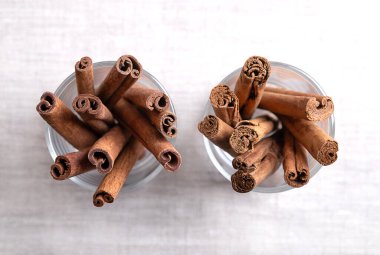 Cassia ve Seylan tarçın çubukları keten kumaşın üzerinde gözlük takıyor. Tarçın kabuğunun tamamı solda, ve Tarçın Zeylanicum sağda, hem baharat hem de gıda katkı maddesi olarak kullanılıyor..