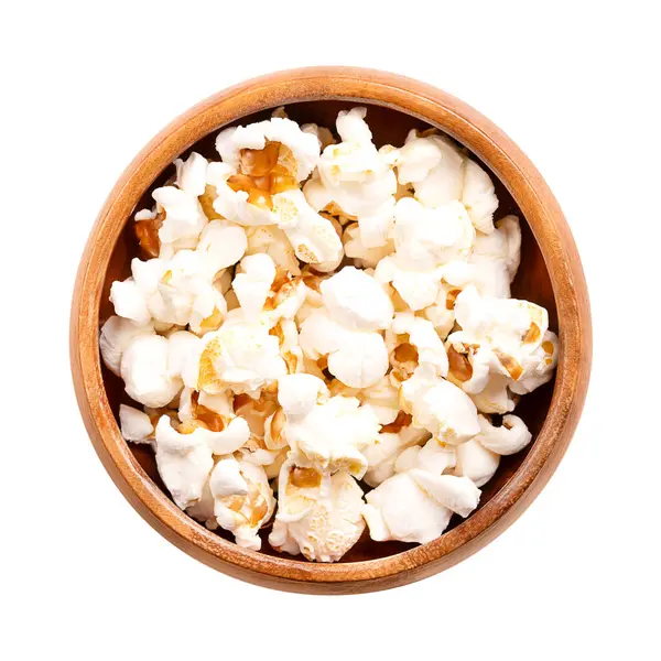 Patlamış mısır, tahtadan bir kasede patlamış mısır. Zea mays tohumları her zaman çeşitlidir, ısındıktan sonra genişler ve şişer. Abur cubur, patlamış mısır ve patlamış mısır olarak da bilinir, mantar ve kelebek şekilli..