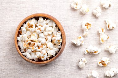 Patlamış mısır, keten kumaş kaplı ahşap bir kasede patlamış mısır. Zea mays 'in tohumları ısındıktan sonra genişledi ve şişti. Abur cubur, patlamış mısır ve patlamış mısır da denir..